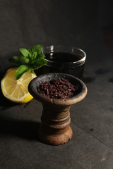 bowl with tobacco for hookah. fruits on a black background. smoking hookah