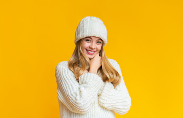 Sweet winter girl posing over yellow background