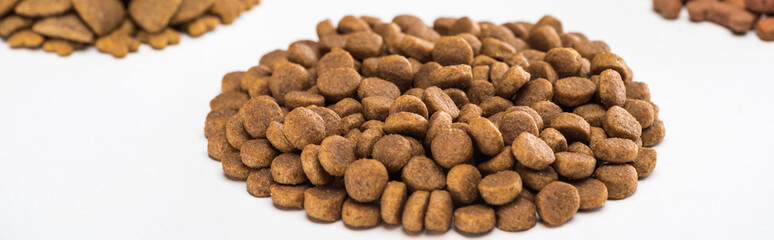 selective focus of fresh dry pet food in pile isolated on white, panoramic shot