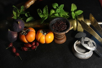 bowl with tobacco for hookah. fruits on a black background. smoking hookah