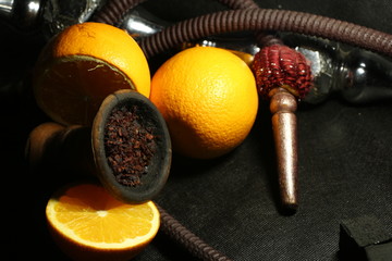 bowl with tobacco for hookah. fruits on a black background. smoking hookah