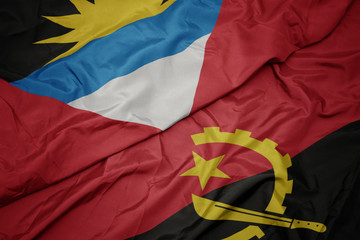 waving colorful flag of angola and national flag of antigua and barbuda.