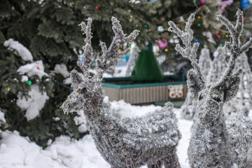 Silver deers from shiny garlands in outdoor park, design of a recreation area for children