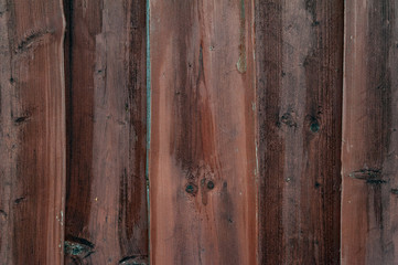Wooden fence. Close-up of wooden planks painted brown.