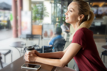 happy woman with coffee and smartphone in coffee shop or cafe. Concept of relaxing people, modern working women freelancer