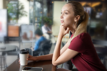 happy woman with coffee and smartphone in coffee shop or cafe. Concept of relaxing people, modern working women freelancer