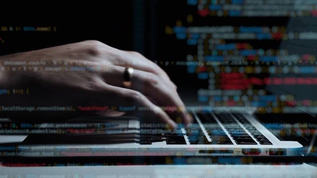 Cinematic close up of hands typing code on a keyboard with Multiple layers of codes and programmer shown beneath them. Hacking programming concept.
