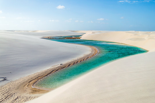 A beautiful turquoise river flowing through white dunes in Brazil