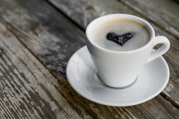 Cup of hot coffee on the wooden table