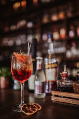 Fototapeta na wymiar London, UK. 16.05.2017 A close up shot of Aperol Spritz cocktail with a bottle of Aperol behind it. Classic alcoholic cocktail from Northern Italy. Concept of hospitality and summer drinks.