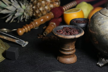 Obraz na płótnie Canvas bowl with tobacco for hookah. passion fruit on a dark background. smoking hookah