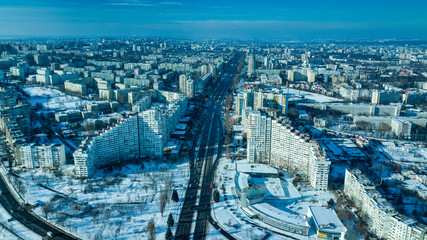 Naklejka na ściany i meble Top view of city in winter at sunset on sky background. Aerial drone photography concept. Kishinev, Republic of Moldova.