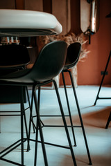 Black tall bar chairs. Colorful minimalist designer interior in orange tones. Modern clean trend design. Simplicity, concept, close up/