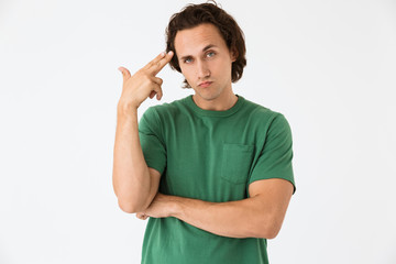 Image of confused young man holding gun fingers at his temple