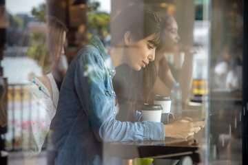 happy hispanic woman, south american latin woman drinking coffee and using smartphone; concept of urban lifestyle in coffee shop with mobile app, smartphone technology, 4G, 5G, internet of things