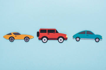 top view of paper cut various cars on blue background