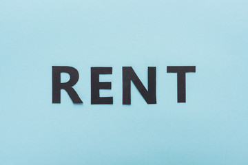 top view of paper cut black rent lettering on blue background