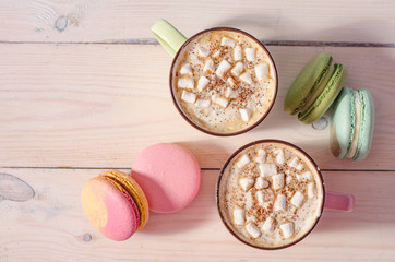 Cup of coffee and colorful macaron on white wooden background top view. Cozy breakfast. Fashion flat lay. Sweet macaroons.
