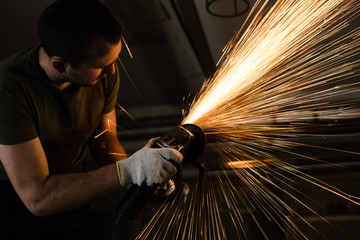 A man works with metal and sparks fly beautifully