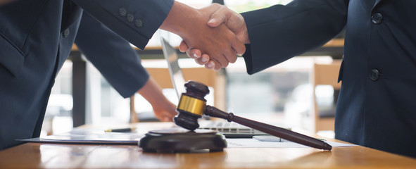 Close up business people shake hands after reaching a legal agreement.