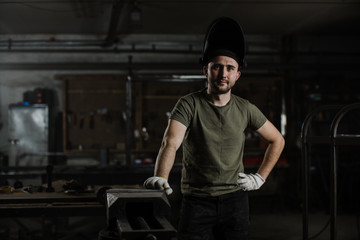 Fototapeta na wymiar Portrait of a young handsome male welder in a protective mask on his head