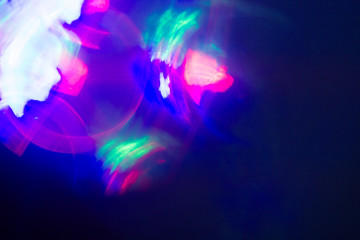 Fototapeta na wymiar Blurred lens flare. Defocused colorful lights. Shiny glowing spots, abstract background and texture