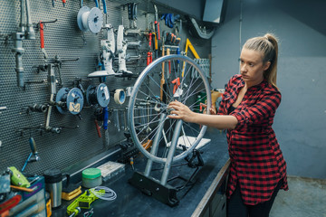 Caring for you wheels. Woman mechanic working in the garage