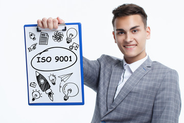 Business, technology, internet and network concept. Young businessman shows a keyword: ISO 9001