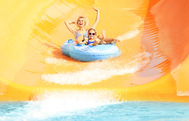 Little girl and her mother having fun in aqua park