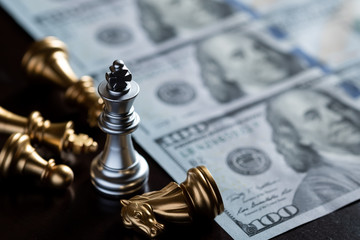 Chess King stand over the enemies with US dollar banknote. The winner in business competition....