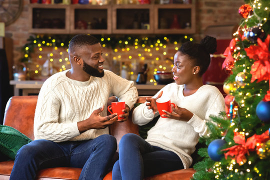 Romantic african american couple drinking hot chocolate, enjoying winter holidays