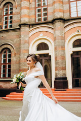 Cute bride circling on the ground near the exclusive building