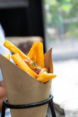Delicious french fries topping with cheddar cheese cream and crispy bacon on close up side view.