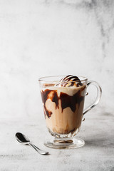 Chocolate frappe with whipped cream, chocolate syrup and ice cream on bright marble background....