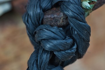 Cuerda de nailon anudada a un soporte de hierro oxidado.