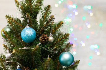 Beautiful green Christmas tree decorated with balls and garlands. Close-up photo. Sparkling background