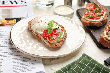 Plate with tasty sandwich on table