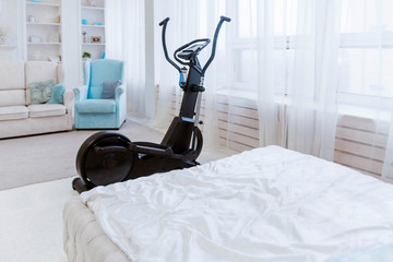 Sports equipment an elliptical trainer stands in the living room