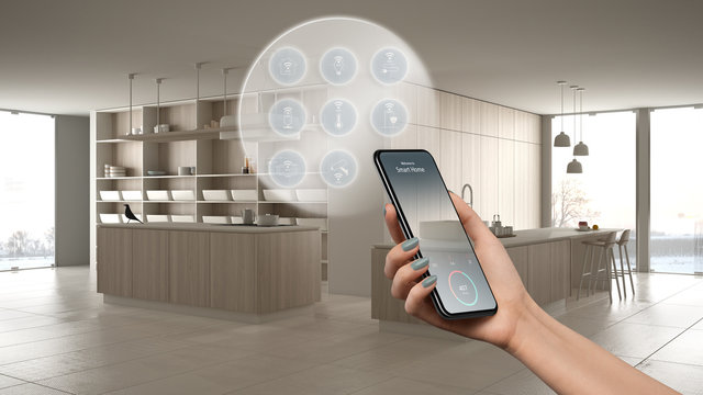 Smart home technology interface on phone app, augmented reality, internet of things, interior design of modern kitchen with connected objects, woman hand holding remote control device