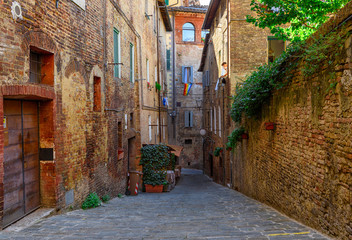 Medieval narrow street in Siena, Tuscany, Italy. Architecture and landmark of Siena. Cozy cityscape of Siena