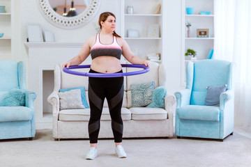 The model is a fat woman, trying to lose weight at home and doing exercises with halajup