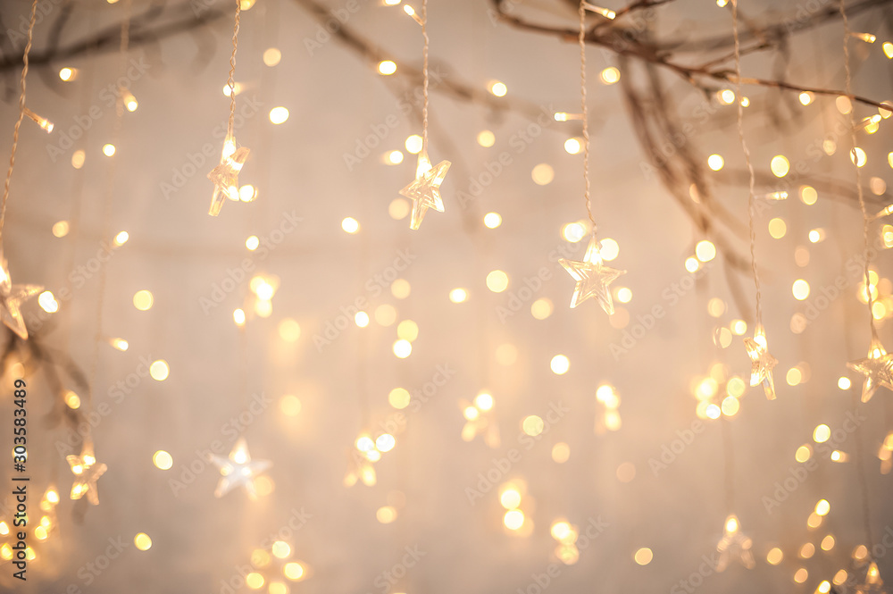 Wall mural background of new year's garlands like stars. christmas atmosphere with garlands in focus and defocu