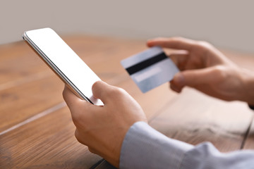 Smartphone with blank screen and credit card in man's hands