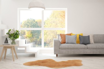 Stylish room in white color with sofa and autumn landscape in window. Scandinavian interior design. 3D illustration