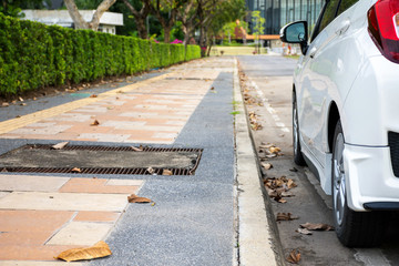 Rear view of new white hatchback car parking on roadside.
