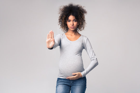 African-american pregnant woman gesturing stop to camera