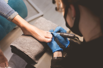 Pedicure master uses nail file drill 