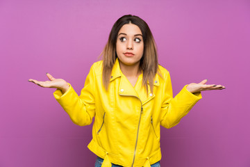 Young woman over purple background having doubts with confuse face expression