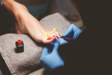 Cercles muraux Pédicure Master does pedicure for client. Pedicure process. Girl draws toenails