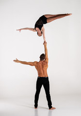 Duo Of Acrobats Showing hand to hand Trick, Isolated On White